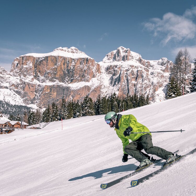 Sciatore sulle piste della Val di Fassa con vista sul Pordoi | © Patricia Ramirez - Archivio Immagini ApT Val di Fassa